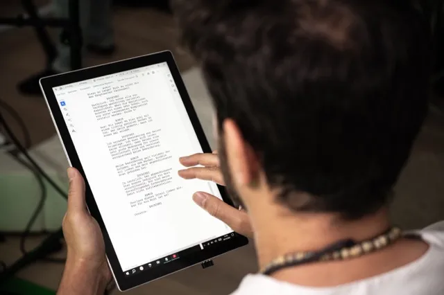 Person liest konzentriert ein Drehbuch auf einem Tablet